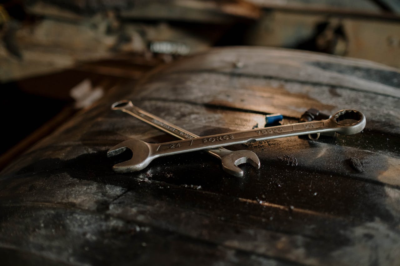 Close-up view of wrenches placed on a textured surface in a workshop setting.