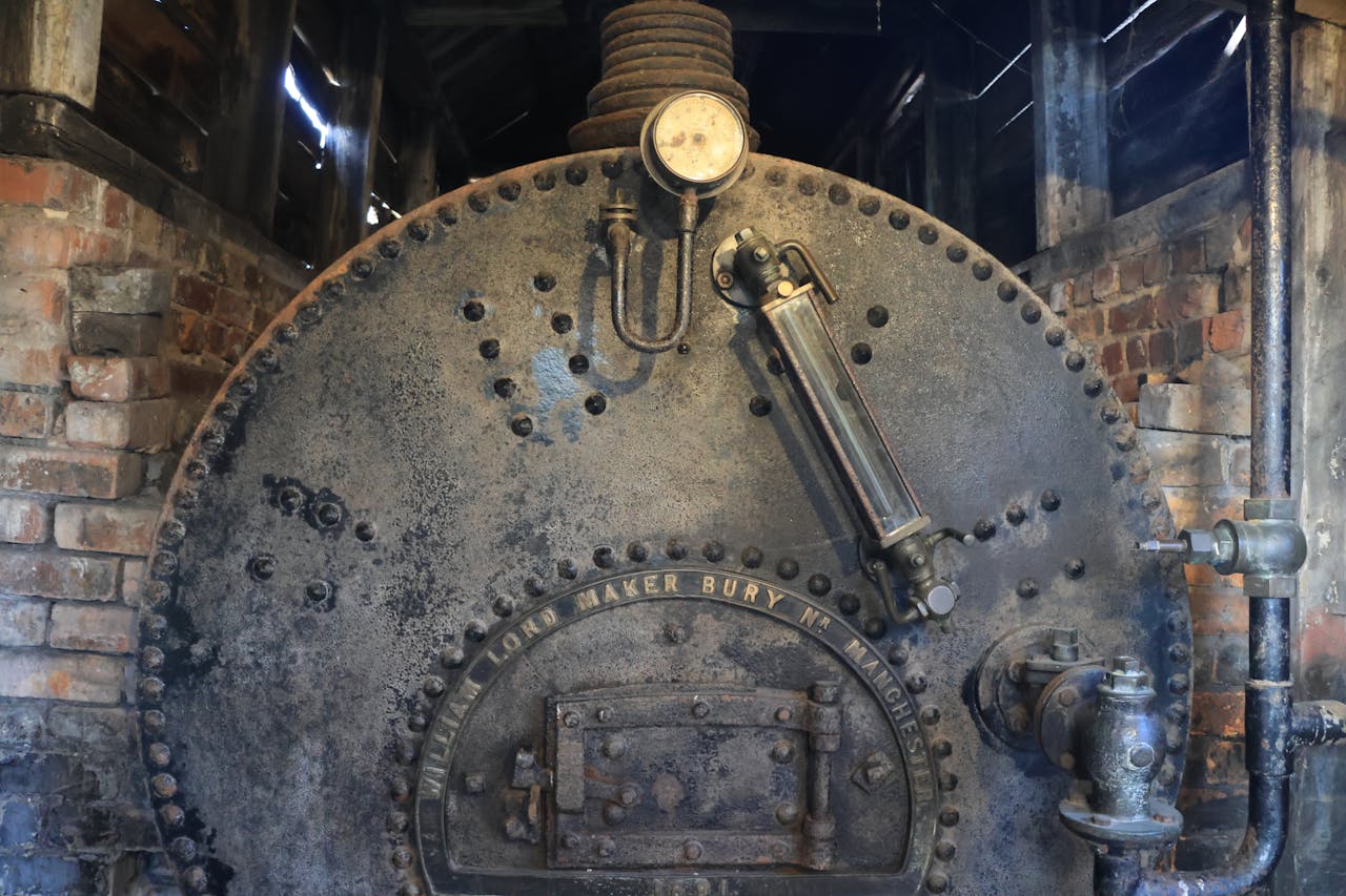 Rustic industrial boiler with intricate metalwork and brick surroundings in Marston, England.